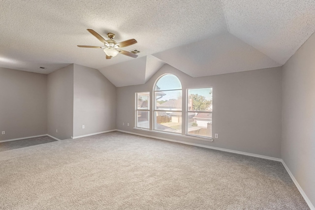 unfurnished room featuring a textured ceiling, carpet, and lofted ceiling