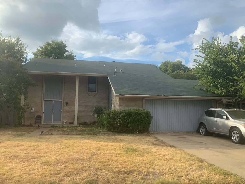 view of front of home featuring a garage and a front lawn