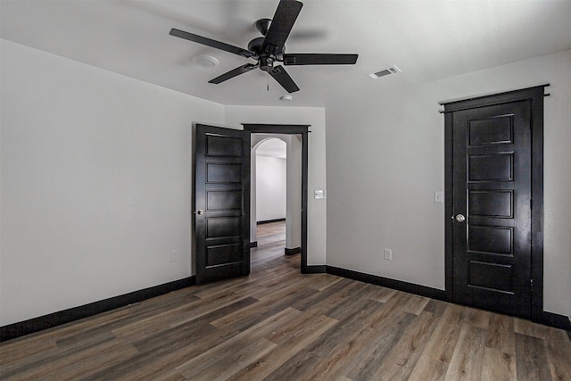 unfurnished room with ceiling fan and dark wood-type flooring