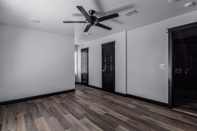 unfurnished bedroom with ceiling fan and dark hardwood / wood-style flooring