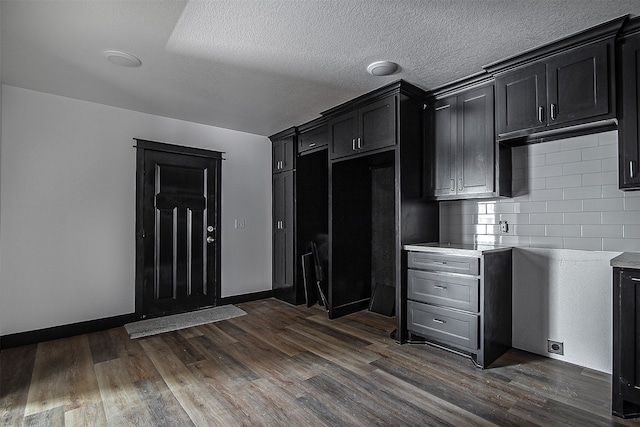 kitchen featuring a textured ceiling, dark hardwood / wood-style flooring, and tasteful backsplash