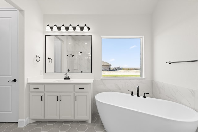 full bathroom featuring a freestanding tub, tile patterned floors, a shower, and vanity