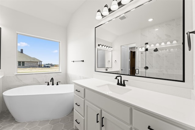 full bath featuring visible vents, a stall shower, vaulted ceiling, vanity, and a freestanding tub