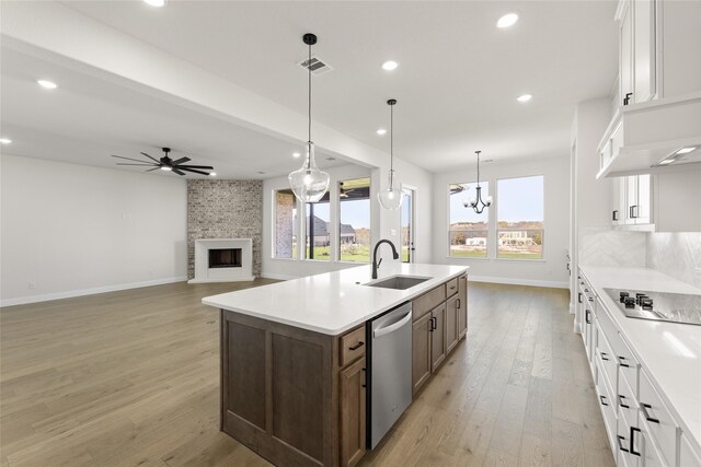 170 Waterview Dr, Gunter, TX 75058 - kitchen with a large fireplace, black electric stovetop, dishwasher, recessed lighting, and a sink