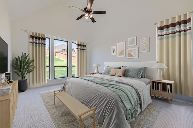 bedroom with ceiling fan, high vaulted ceiling, and light carpet