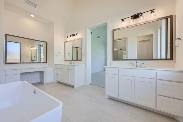 bathroom with tile patterned floors, vanity, lofted ceiling, and a tub to relax in