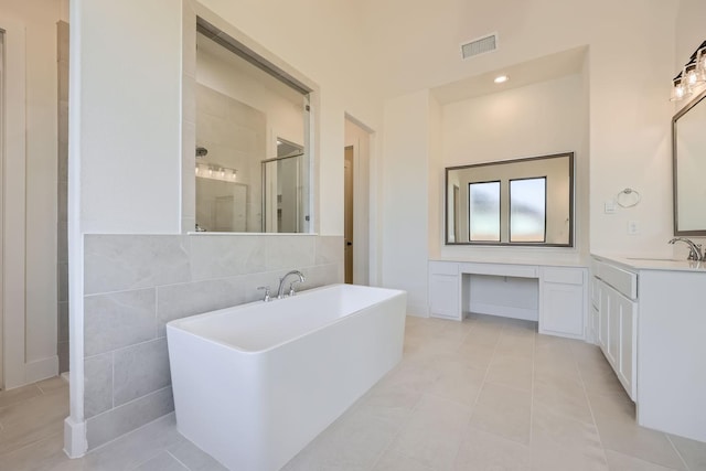 bathroom featuring tile patterned flooring, vanity, tile walls, and independent shower and bath