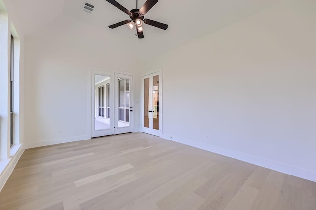 empty room featuring ceiling fan, french doors, vaulted ceiling, and light wood-type flooring