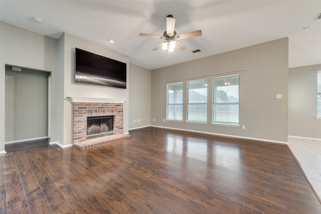 unfurnished living room with dark wood-type flooring, a fireplace, and ceiling fan