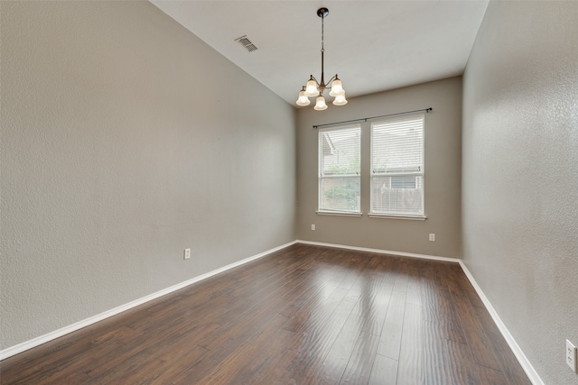 unfurnished room featuring a chandelier and dark wood-type flooring