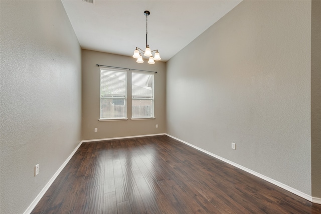 unfurnished room with a chandelier and dark hardwood / wood-style flooring