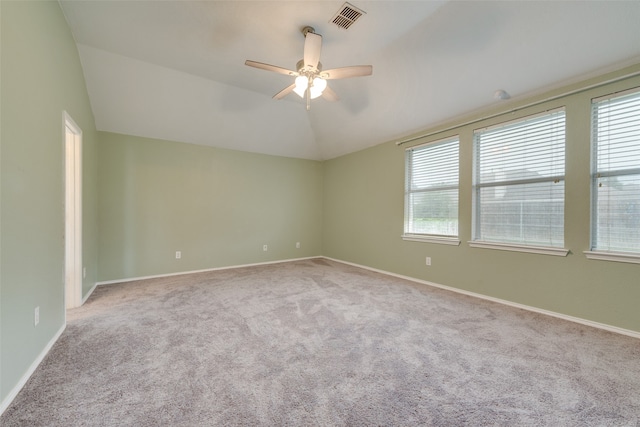 spare room featuring ceiling fan, vaulted ceiling, and light carpet