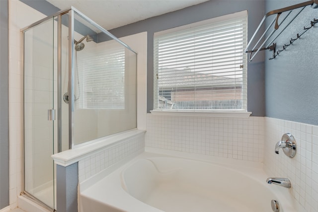 bathroom featuring separate shower and tub