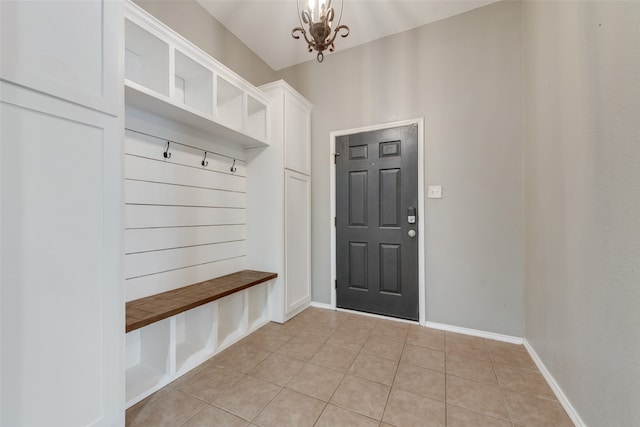 mudroom with an inviting chandelier and light tile patterned floors