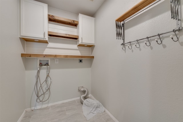 clothes washing area with hookup for a washing machine, cabinets, and electric dryer hookup