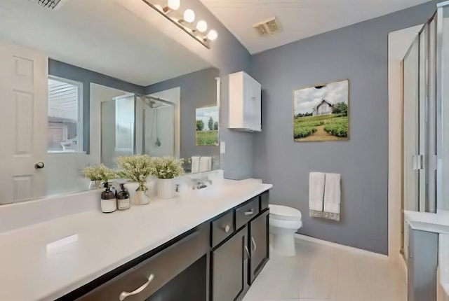 bathroom with vanity, toilet, an enclosed shower, and tile patterned floors