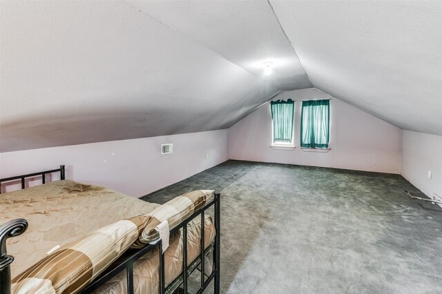 additional living space featuring dark carpet and vaulted ceiling