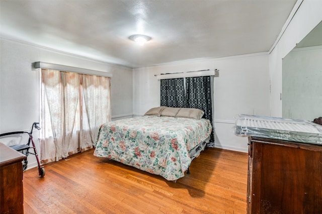 bedroom featuring ornamental molding and wood-type flooring