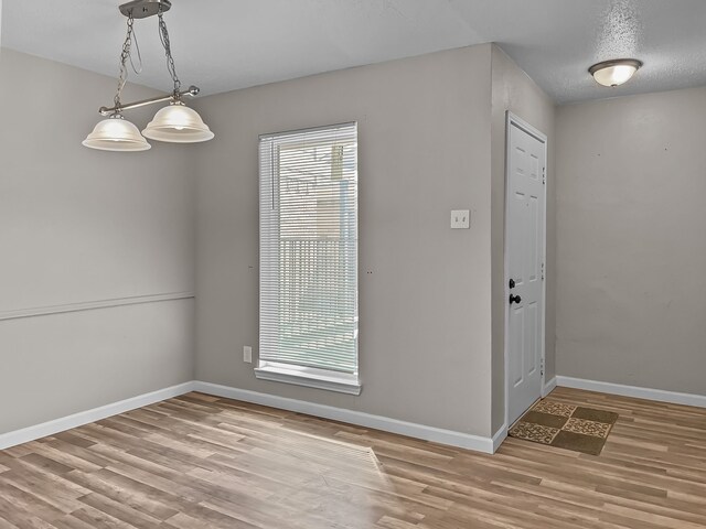 empty room featuring a textured ceiling, light colored carpet, and ceiling fan