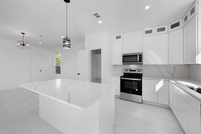 309 W Beckham St W, Sulphur Springs, TX 75482 - kitchen featuring stainless steel appliances, a kitchen island, light wood-type flooring, recessed lighting, and light stone countertops