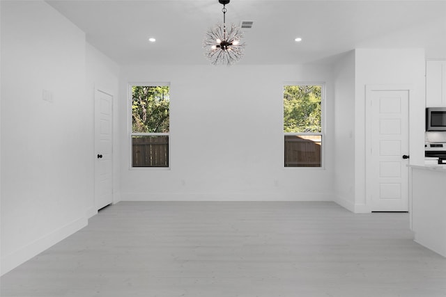 309 W Beckham St W, Sulphur Springs, TX 75482 - spare room with healthy amount of natural light, a chandelier, light wood finished floors, and recessed lighting