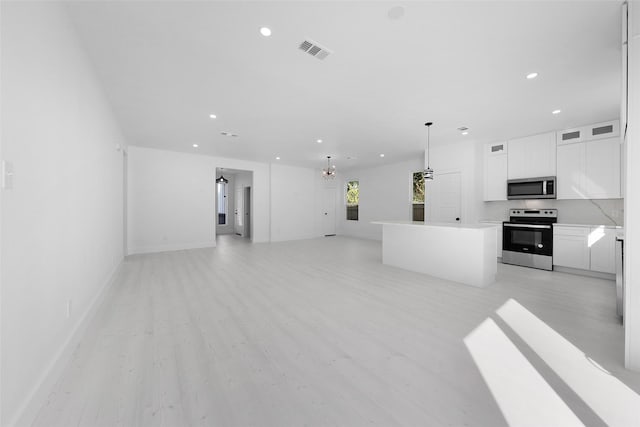 309 W Beckham St W, Sulphur Springs, TX 75482 - unfurnished living room featuring recessed lighting, light wood-type flooring, baseboards, and a chandelier