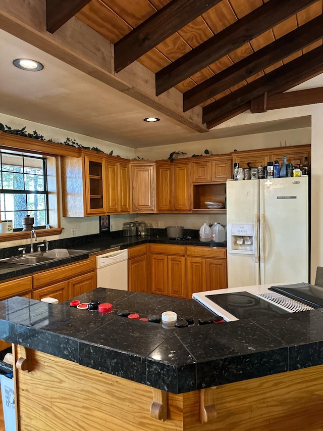 kitchen featuring a breakfast bar, lofted ceiling with beams, sink, a kitchen island, and white appliances