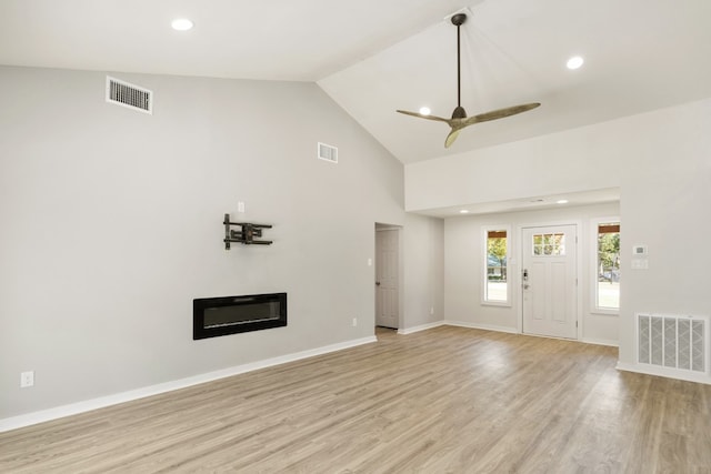 unfurnished living room with high vaulted ceiling, light wood-type flooring, and ceiling fan