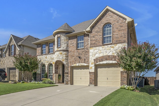 view of front of property featuring a front yard, central AC, and a garage