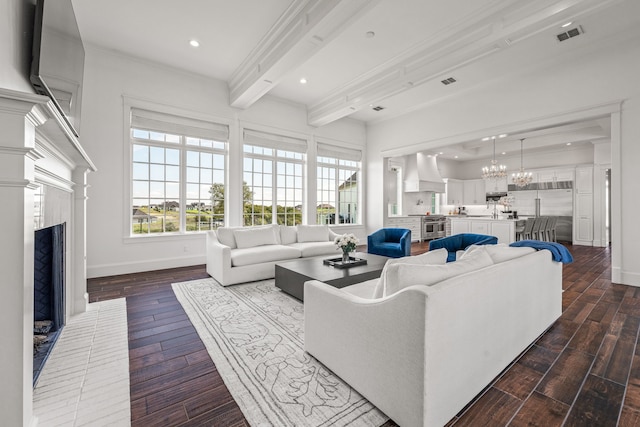 living room with a notable chandelier, ornamental molding, dark hardwood / wood-style floors, and beam ceiling