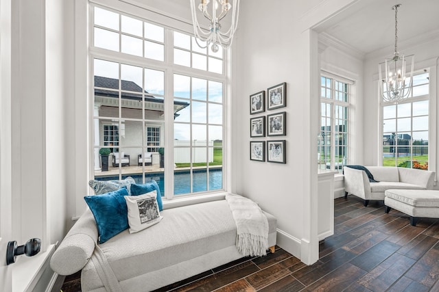 living area featuring an inviting chandelier, dark wood-type flooring, and a healthy amount of sunlight