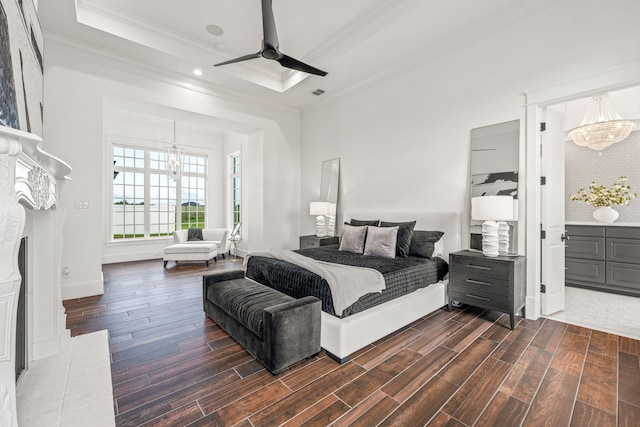 bedroom with connected bathroom, ceiling fan with notable chandelier, dark hardwood / wood-style floors, and crown molding