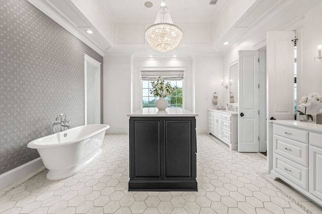 bathroom with an inviting chandelier, vanity, crown molding, and a washtub