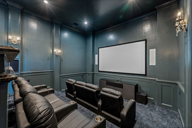 carpeted home theater room with a chandelier and crown molding