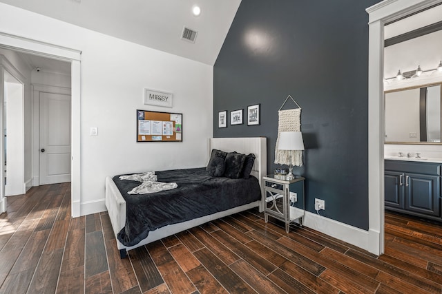 bedroom featuring connected bathroom, dark hardwood / wood-style flooring, and sink