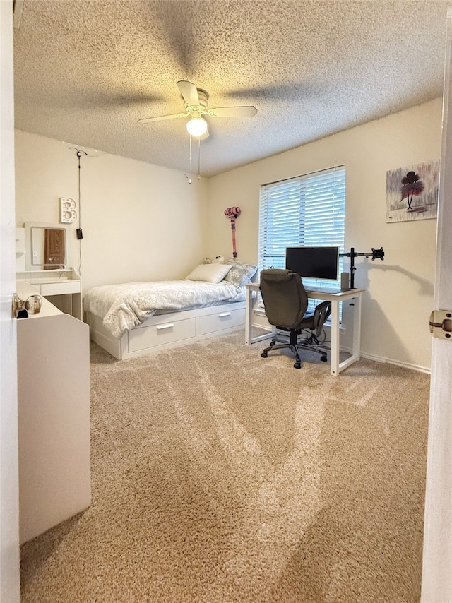 bedroom with light carpet, ceiling fan, and a textured ceiling