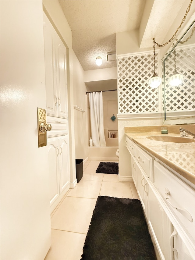 bathroom with vanity, toilet, a textured ceiling, and tile patterned floors