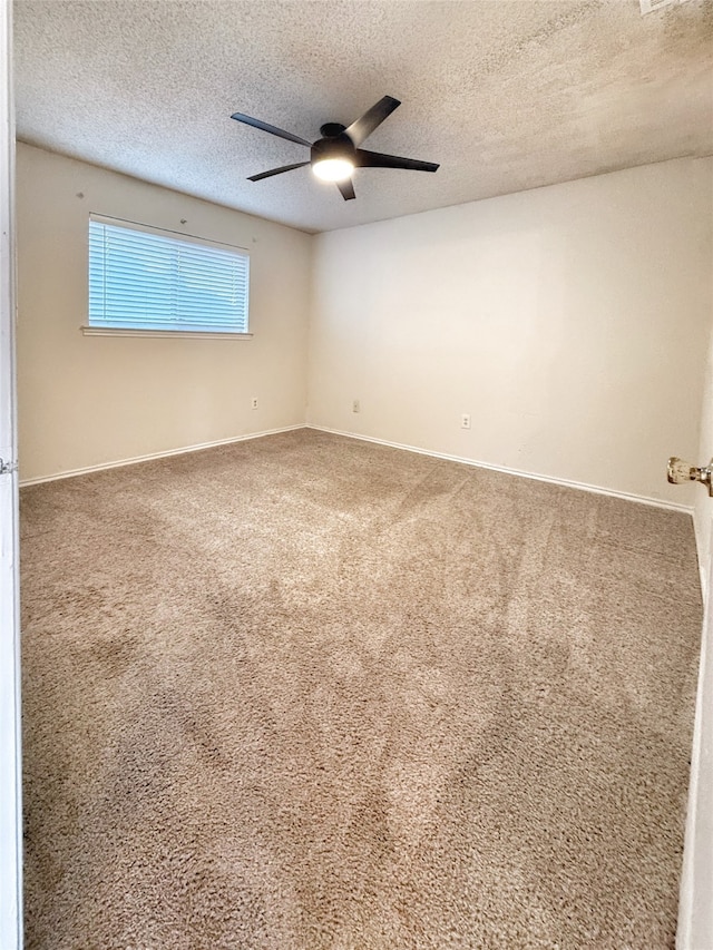 spare room with ceiling fan, a textured ceiling, and carpet floors