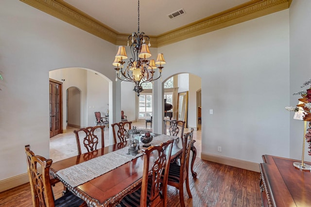 dining area with crown molding, a high ceiling, dark hardwood / wood-style floors, and french doors