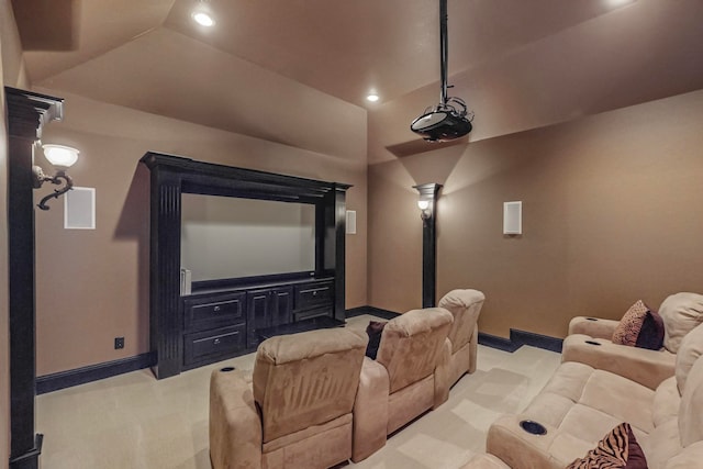 carpeted cinema room featuring decorative columns and vaulted ceiling