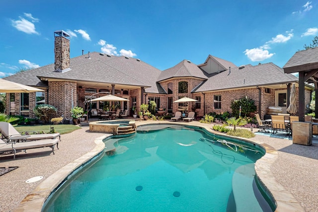 view of swimming pool featuring an in ground hot tub and a patio area