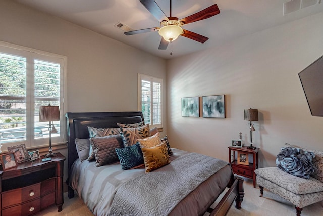 carpeted bedroom featuring ceiling fan and multiple windows