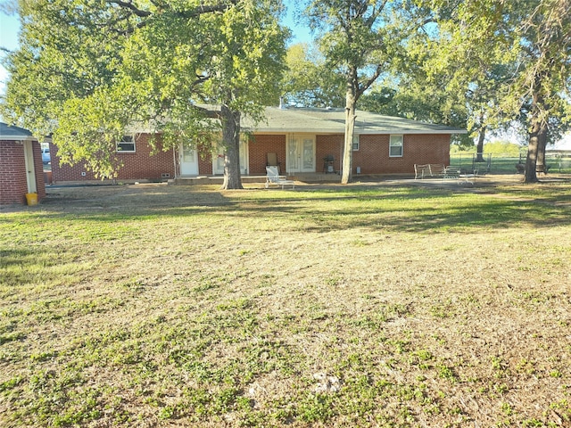 rear view of property featuring a lawn