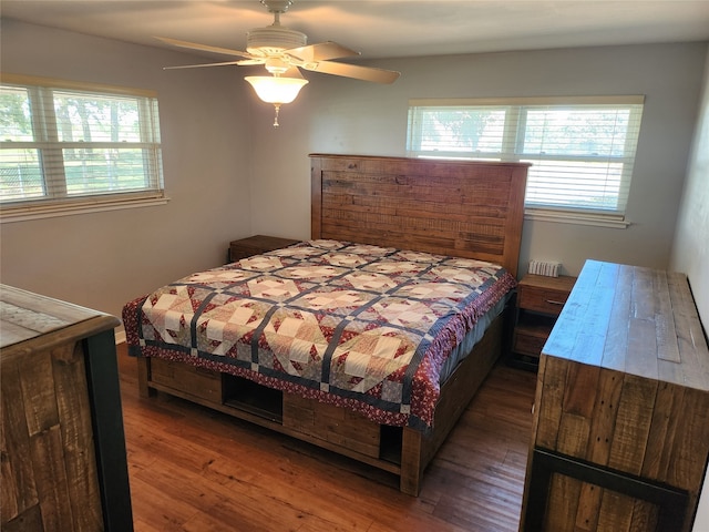 bedroom featuring multiple windows, dark hardwood / wood-style flooring, and ceiling fan