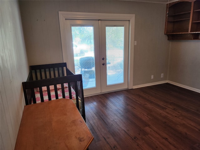 unfurnished bedroom with wood walls, french doors, and dark hardwood / wood-style flooring