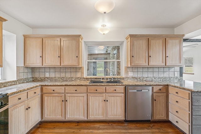 kitchen with decorative backsplash, light brown cabinets, dishwasher, hardwood / wood-style floors, and sink