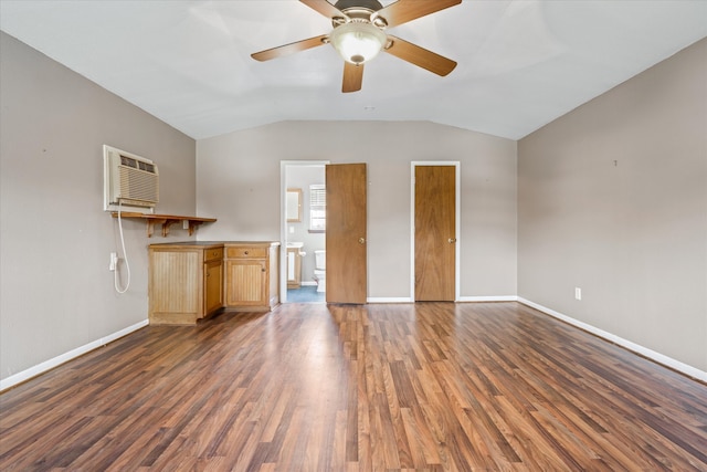 unfurnished living room featuring a wall mounted AC, dark hardwood / wood-style flooring, ceiling fan, and vaulted ceiling