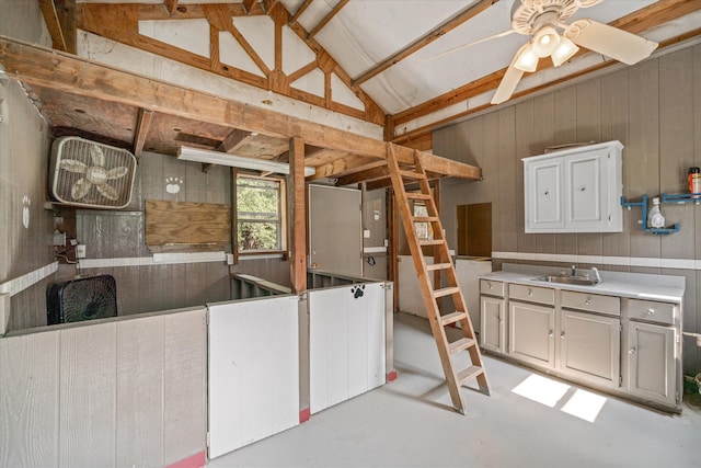 interior space featuring ceiling fan, sink, and vaulted ceiling