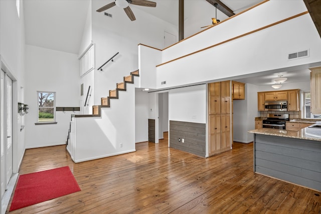 foyer with ceiling fan, light wood-type flooring, sink, and high vaulted ceiling