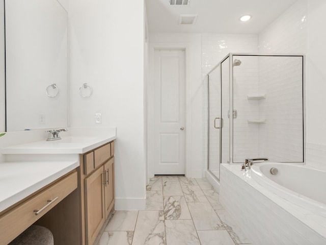 bathroom featuring vanity and independent shower and bath